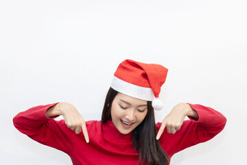 Asian woman in santa claus hat point down to blank copyspace