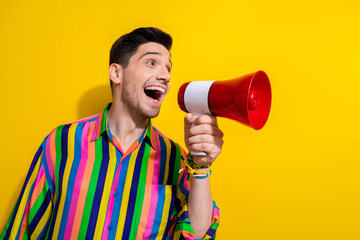Photo of young guy telling people the political truth using only megaphone at central area in crowd isolated over yellow color background