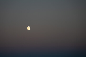 Full moon against a subtitle sunset sky.