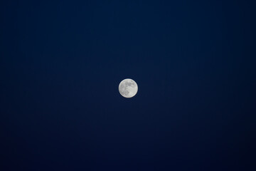 Full moon against a dark blue sky.