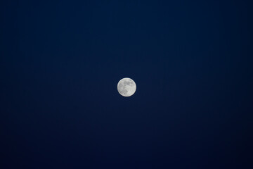 Full moon against a dark blue sky.