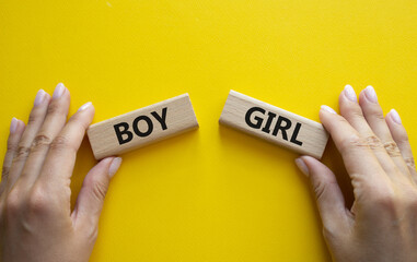 Boy or Girl symbol. Concept word Boy or Girl on wooden blocks. Man hand. Beautiful yellow...