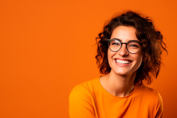 smiling European woman in her 30s. orange background