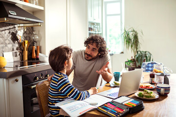 Father Helping Son with Homework in a Home Kitchen