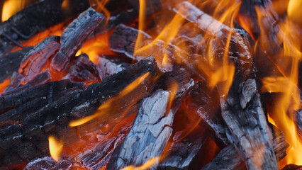 Close-up of burning charcoal. Burning fire, red and yellow flames. Wood, charcoal in charcoal grill. Cooking on charcoal.