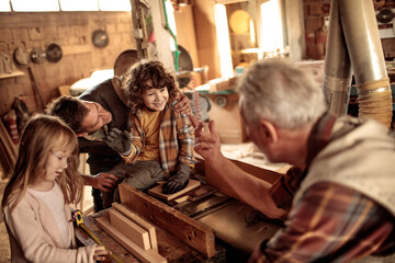 Obraz na płótnie Canvas Multi generational family in the woodworking workshop