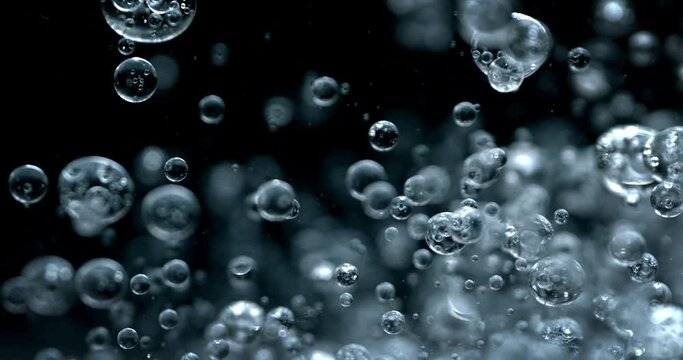 Slow motion macro of floating micro particles molecules in liquid are analyzed with microscope by chemist during innovative new medical research and analysis in scientific pharmaceutical laboratory.
