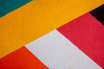 rough wall texture with stripes of yellow, green, black, red, orange and white