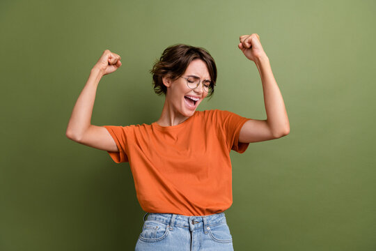 Photo of young craziest funny successful businesswoman fists up screaming hooray phrase achievement isolated on green color background