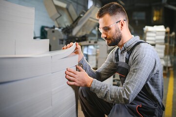 Man working in printing house with paper and paints