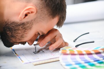 Man working in printing house with paper and paints