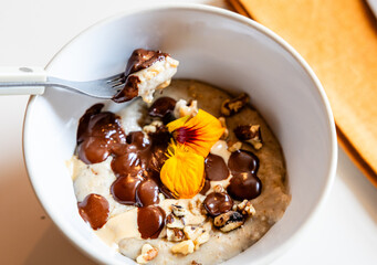 Close-up of a bowl of healthy food, oatmeal, chocolate, fruit