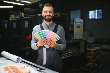 Typographer standing with color swatches at the printing manufacturing
