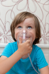 Blue-eyed boy being treated with nebulizer, child treating lungs, breathing medication