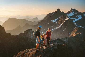Family hiking together travel in Norway mountains: parents and child outdoor climbing adventure healthy lifestyle outdoor active vacations mother and father with kid trekking - obrazy, fototapety, plakaty