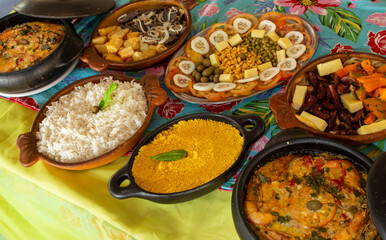 Pratos típicos nordestinos do Brasil, em panelas de barro com comidas variadas em uma mesa farta