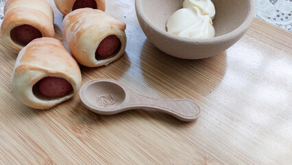 Bread rolled in a sausage on top of a wooden table