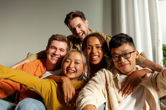 multiracial group of young friends smiling and taking selfies for the camera, asian, african american and european