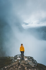 Woman tourist hiking alone in foggy mountains Norway, girl enjoying misty view adventure vacations healthy outdoor lifestyle, moody landscape - obrazy, fototapety, plakaty