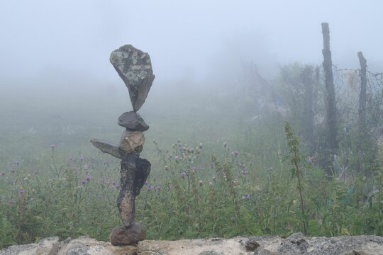 a stone statue on top of a pile of stones in a field