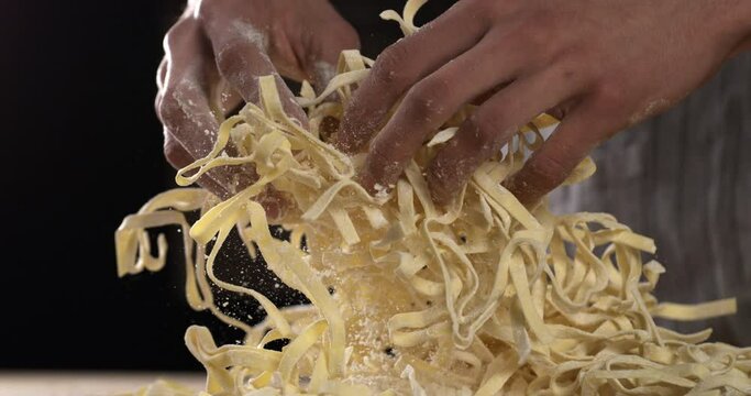 Cook baker preparing in extreme macro slow-motion spaghetti with organic flour a pasta laboratory. The concept of a skilled chef stands at the workplace masters new pasta cooking   tradition.1000 fps.
