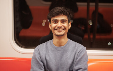 Portrait of young Indian man passenger traveling in the metro. Delhi metro and Public...