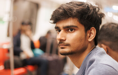 Portrait of young Indian man passenger traveling in the metro. Delhi metro and Public...