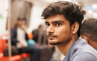 Portrait of young Indian man passenger traveling in the metro. Delhi metro and Public transportation concept. 