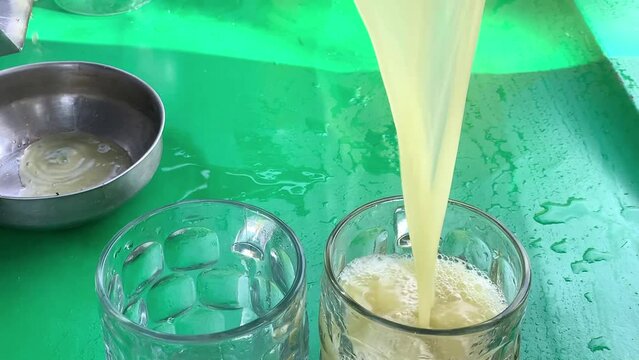 Man make eco sugarcane juice. Rural guy produce sweet rum drink. Street vendor chop up raw cane fiber. Local maker sell sugar sap. Grinder mill crush sugarcanes fibre. Slow motion Video. Hand work. 4K