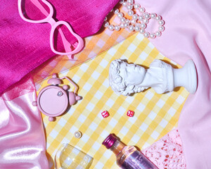 Creative pink yellow background with decorative elements of retro aesthetics, checkered pattern tablecloth, gin bottle, aperitif glass and souvenir from Florence, 50s nostalgia.
