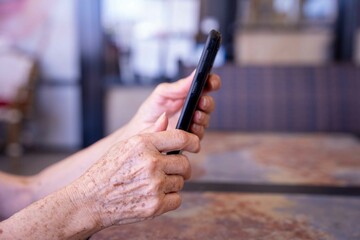 Profile of senior female hands holding a smartphone.