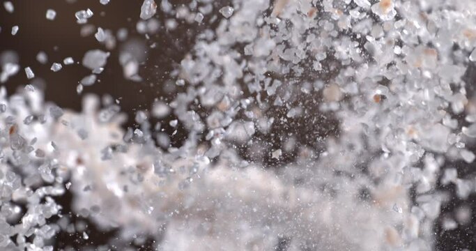 Very Close-up.Pink himalayan rock salt on a delicious background and wood floor passes in front of the camera in slow motion.Macro 1000 fps video.