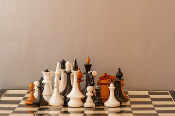 Different sized chess pieces huddled next to each other on a chessboard. Unification of different...