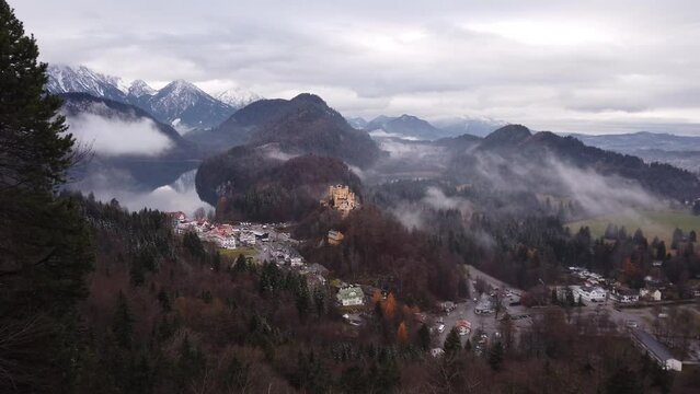 PAN SHOT - Hohenschwangau Village on left, Hohenschwangau Castle on right, as seen from Neuschwanstein Castle in Schwangau, Germany.