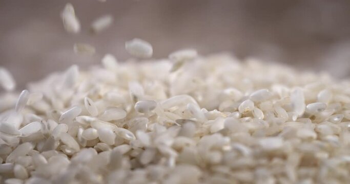 Super slow motion macro of dry basmati quality rice falling on rustic wooden table on restaurant kitchen. Macro, 4K, ,Very Close-up, 1000 fps video.