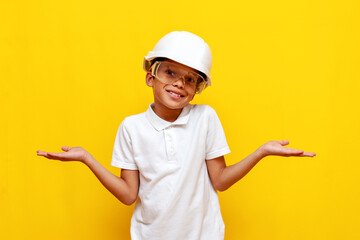 unsure african american boy builder repairman in hard hat and safety glasses shrugs his shoulders...
