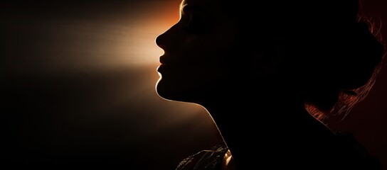  a woman's profile in the dark with a light coming from behind her and a light coming from behind her.