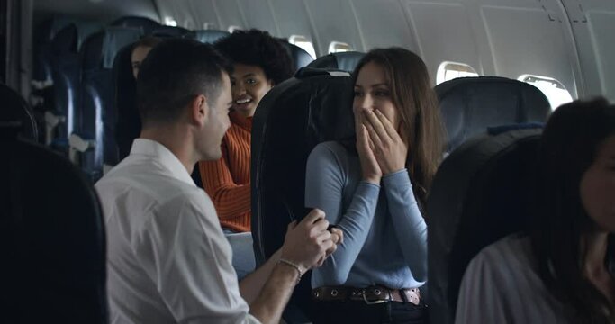 young couple on a plane and a romantic and magical marriage proposal during the flight to an exotic and emotional destination