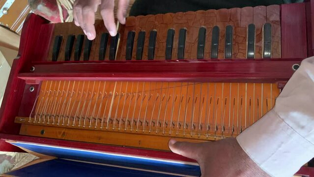 A Man Playing Harmonium. Closeup shot of hands of a Man playing Harmonium. Traditional world. Folk instrument. Pakistani man playing harmonium in the house. Beautiful 4K Footage.