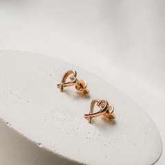 Stylish gold stud earrings in pink gold in the shape of hearts.