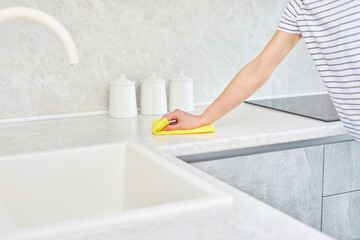 Woman cleaning the kitchen. Female hand hold dishwashing sponge. Housewife cleaning table. Housework and housekeeping concept.