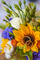 wedding rings in a colorful flower bouquet from the bride and groom