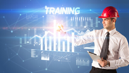 Young businessman with helmet drawing on virutal screen