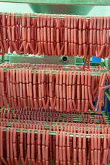 rack with sausages wiener and bratwurst , hotdog raw in the factory