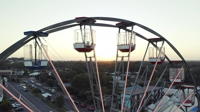 Drone, moving and ferris wheel for travel in city, lens flare and street view of amusement park for leisure. Cape town, sunset and urban in waterfront for mapping, tourist and destination vacation
