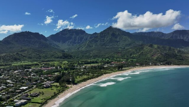Aerial Kauai Hawaii Hanalei Bay recreation beach slide. Surfing and swimming ocean recreation. Bay cove for swimming, snorkel and surfing. Economy is tourism based. Tourist enjoy beach and warmth.