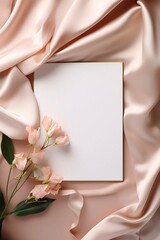 Obraz premium White Invitation Card on Light Pink Satin Sheet with Pink Flowers 