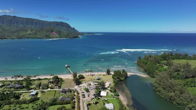 Aerial Kauai Hawaii Hanalei Bay river recreation beach pie. Surfing and swimming ocean recreation. Bay cove for swimming, snorkel and surfing. Economy is tourism based. Tourist enjoy beach and warmth.