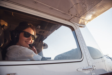 Woman-pilot in aircraft - obrazy, fototapety, plakaty