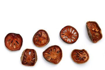 Dried bael fruit slices on white background.